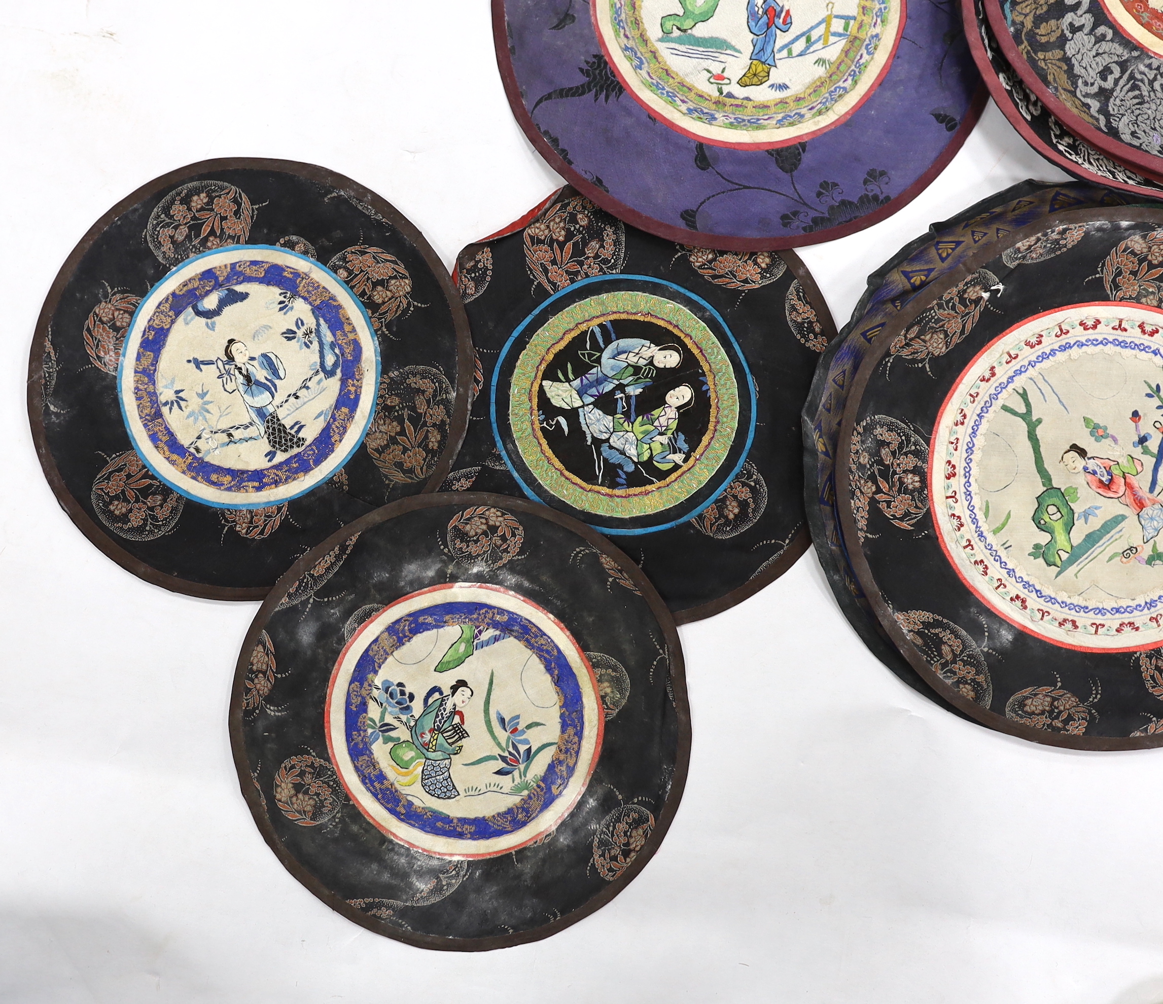 Thirty assorted Chinese silk circular mats, all embroidered with figures, all bordered with silk damask
